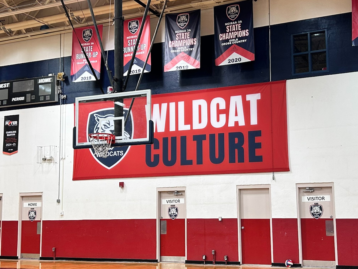 Large red Wildcat Culture banner installed inside a school gymnasium