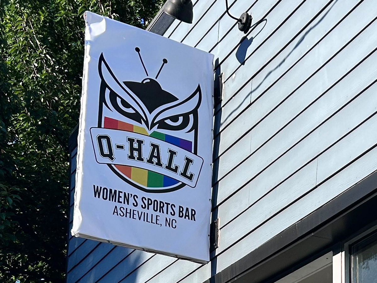 Custom Q-Hall banner fitted over an existing projecting blade sign in Asheville, NC