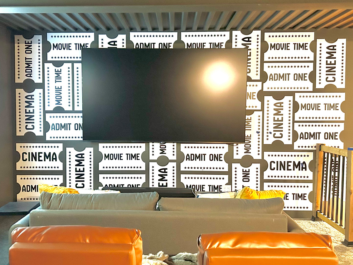 Custom movie ticket wall graphics surrounding a television in a staged Asheville North Carolina home