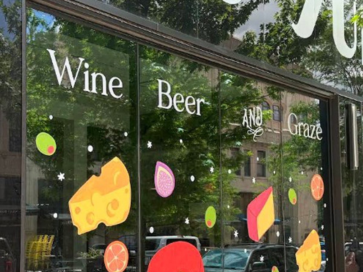 Wine Beer and Graze storefront window graphics with colorful cheese, fruit and decorative illustrations