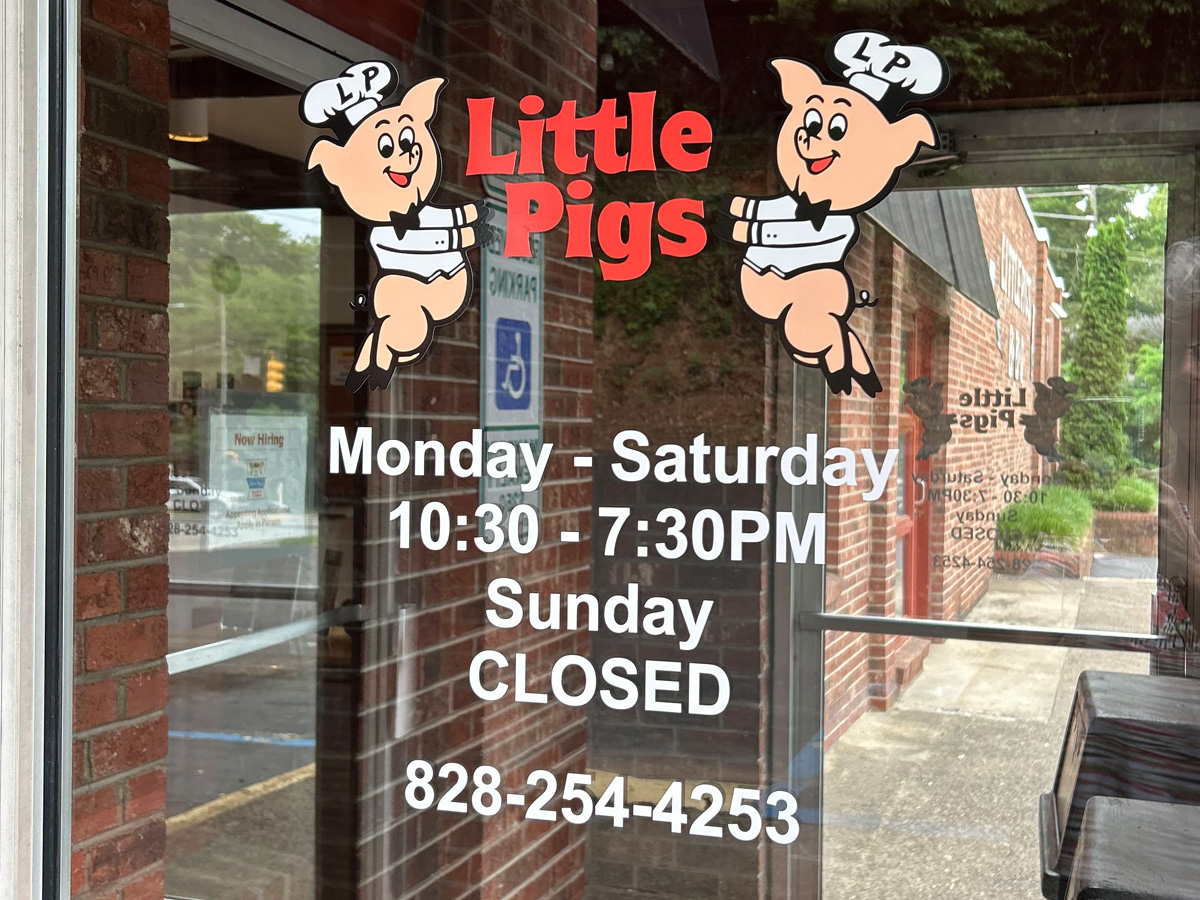 Little Pigs restaurant logo, business hours and phone number installed as window graphics on a glass entrance door
